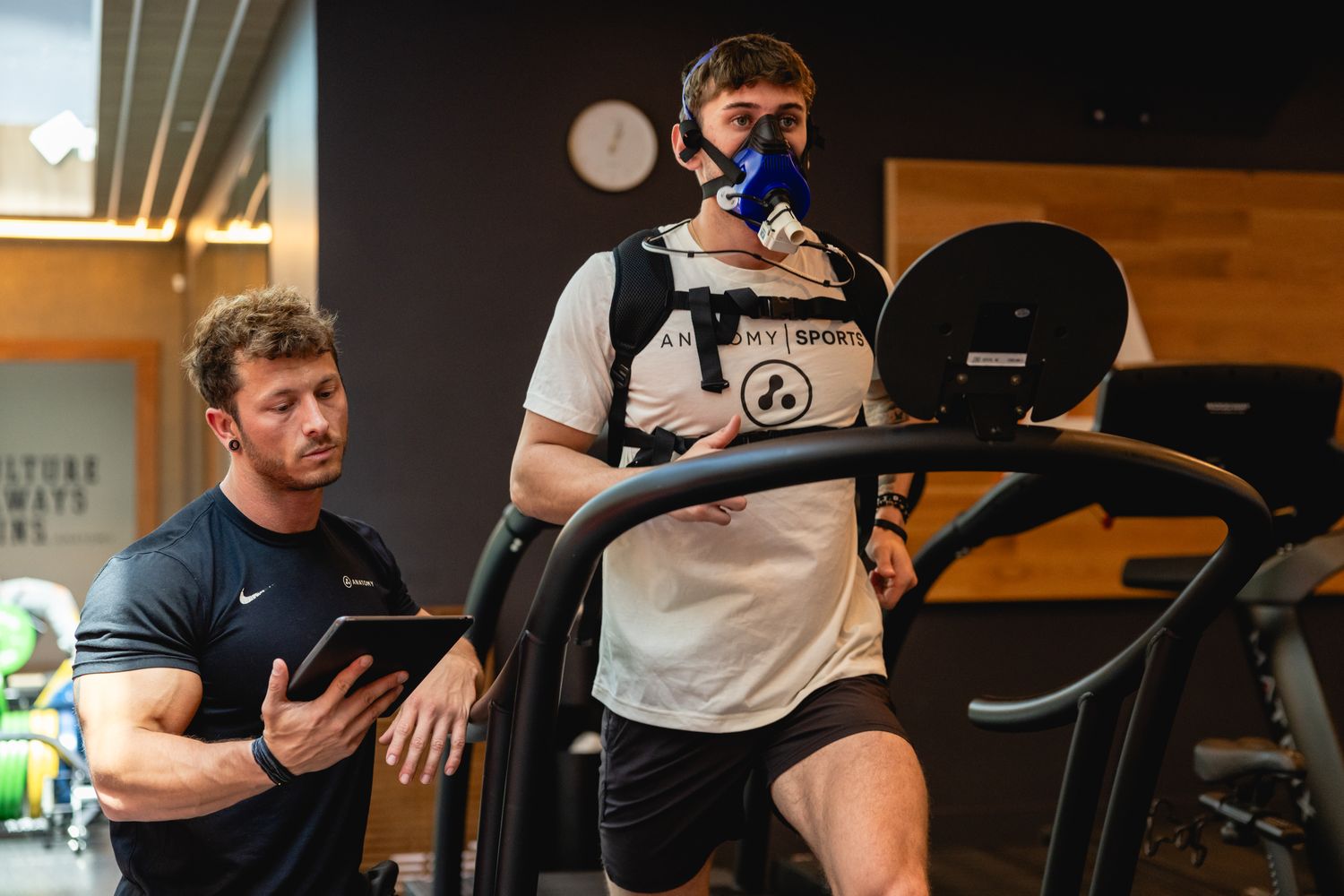 Anatomy coach guiding a member through VO2 max testing on a treadmill
